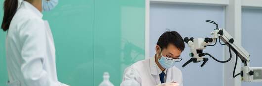 Doctor and nurse operating on female patient