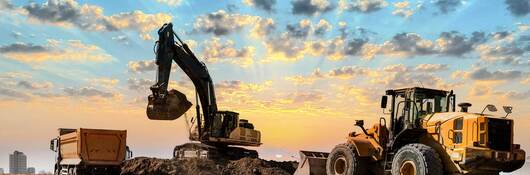 Excavator and bulldozer working together to put dirt into a dump truck