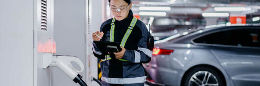 A person inspecting a charging station