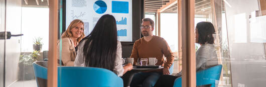 Group of colleagues discussing metrics during an informal meeting