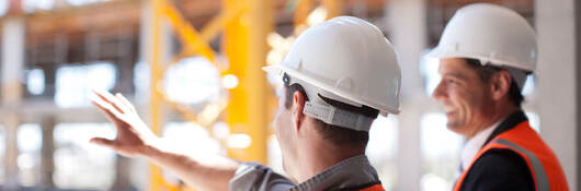 An engineer and architect overlook the construction of a new commercial building