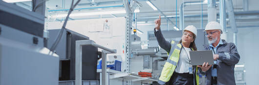 Two managers inspecting and discussing an industrial facility