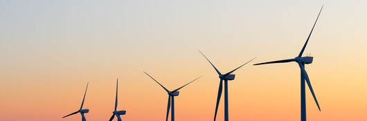 A line of wind turbines at dusk