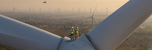 Two engineers on top of a wind turbine