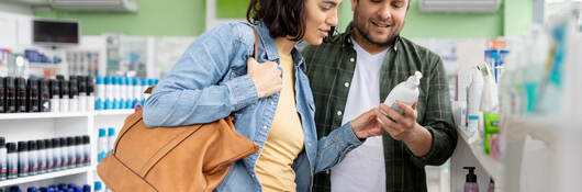 A couple reading a label while shopping for personal care items together