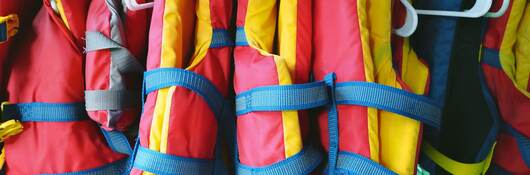 Colorful life jackets hanging in a row