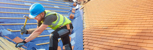 A person replacing roof tiles