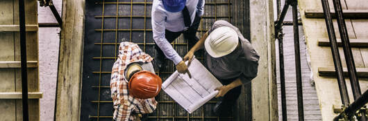 Three contractors looking at construction plans