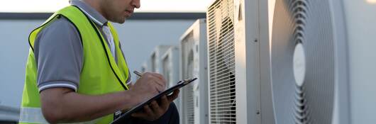 Man inspecting an outdoor unit of air conditioner