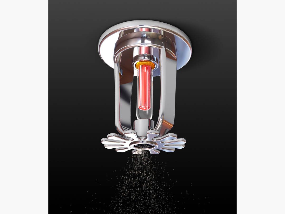 A fire sprinkler head dispersing water 