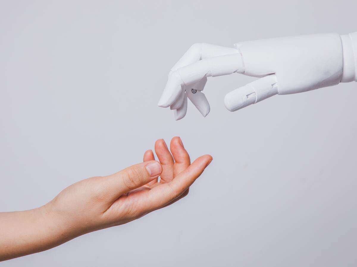 Human hand reaching for robotic hand.
