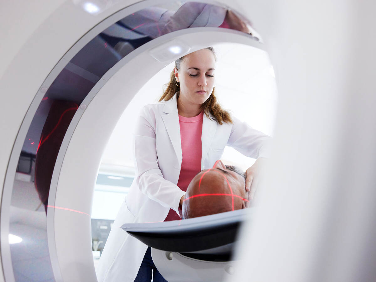 radiologist helping patient in medical x-ray scanner