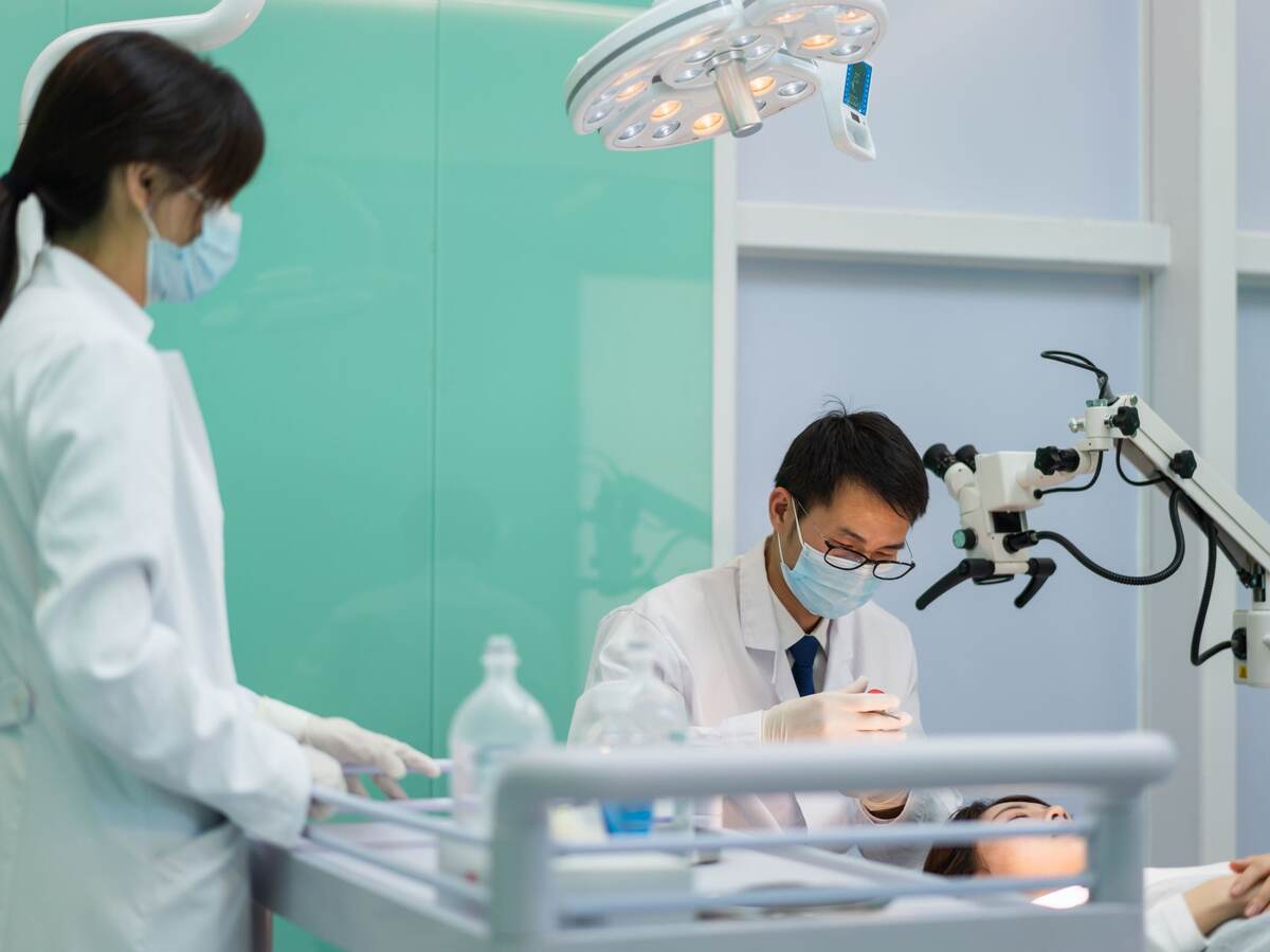 Doctor and nurse operating on female patient