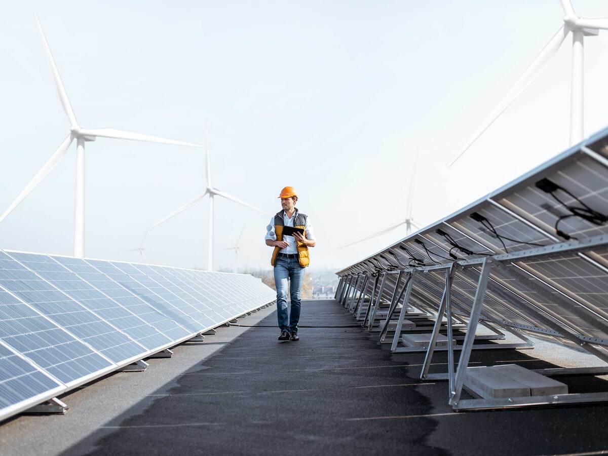 Engineer walking down a row of solar panels