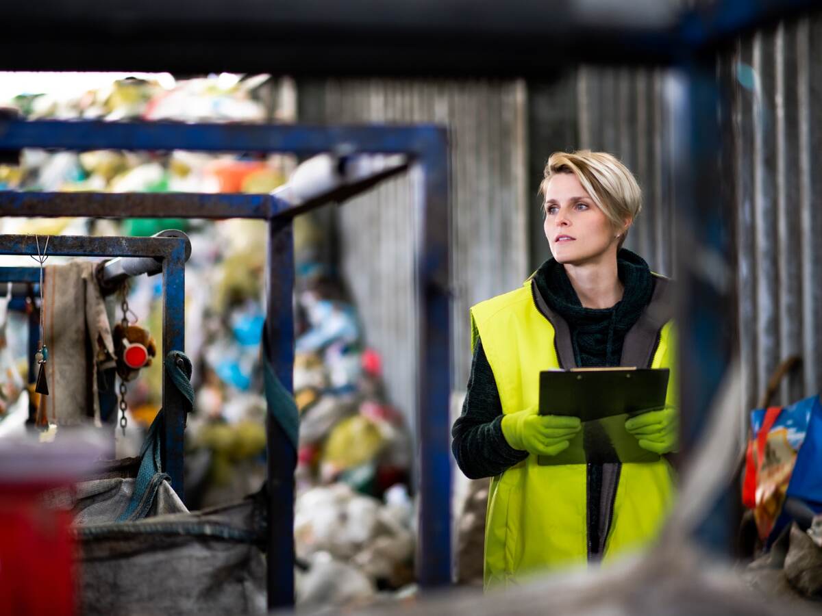 Woman worker on landfill, waste management and environmental concept.