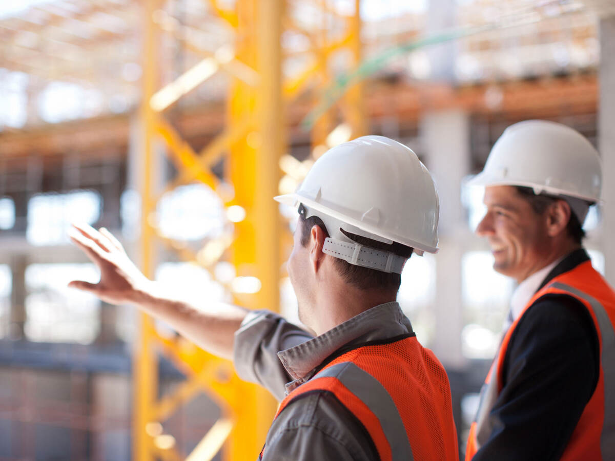 An engineer and architect overlook the construction of a new commercial building