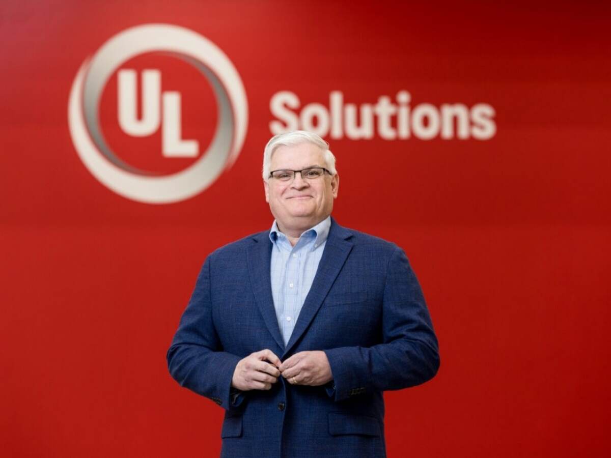 Portrait of Tony Worthan from the waist up in front of a red UL Solutions logo