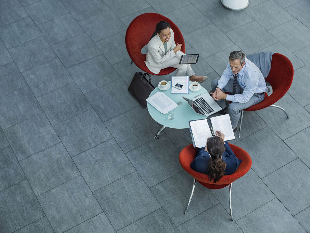 Overhead view of three people having an informal meeting