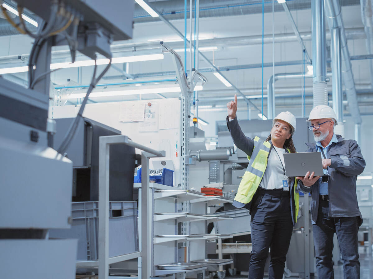 Two managers inspecting and discussing an industrial facility