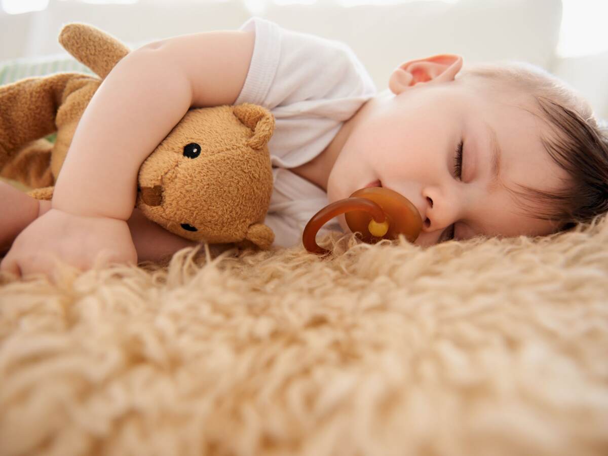 Baby boy sucking his pacifier during nap time