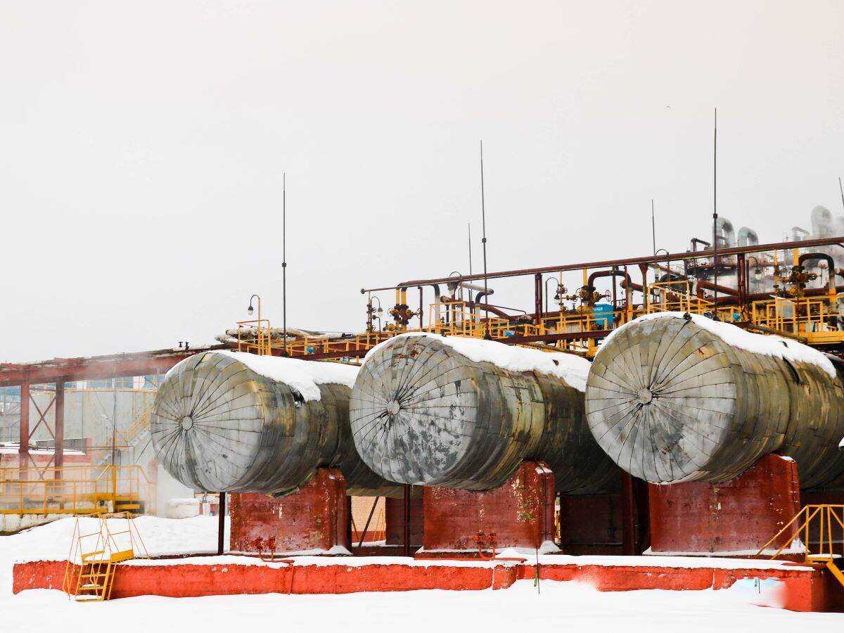 Large horizontal shell-and-tube tanks heat exchangers with liquid at an industrial petroleum refining petrochemical chemical plant in the snow in winter