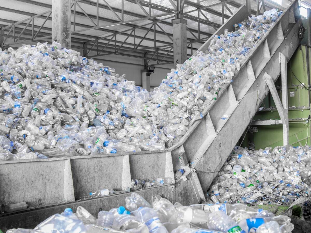 Closeup escalator with a pile of plastic bottles at the factory for processing and recycling. PET recycling plant