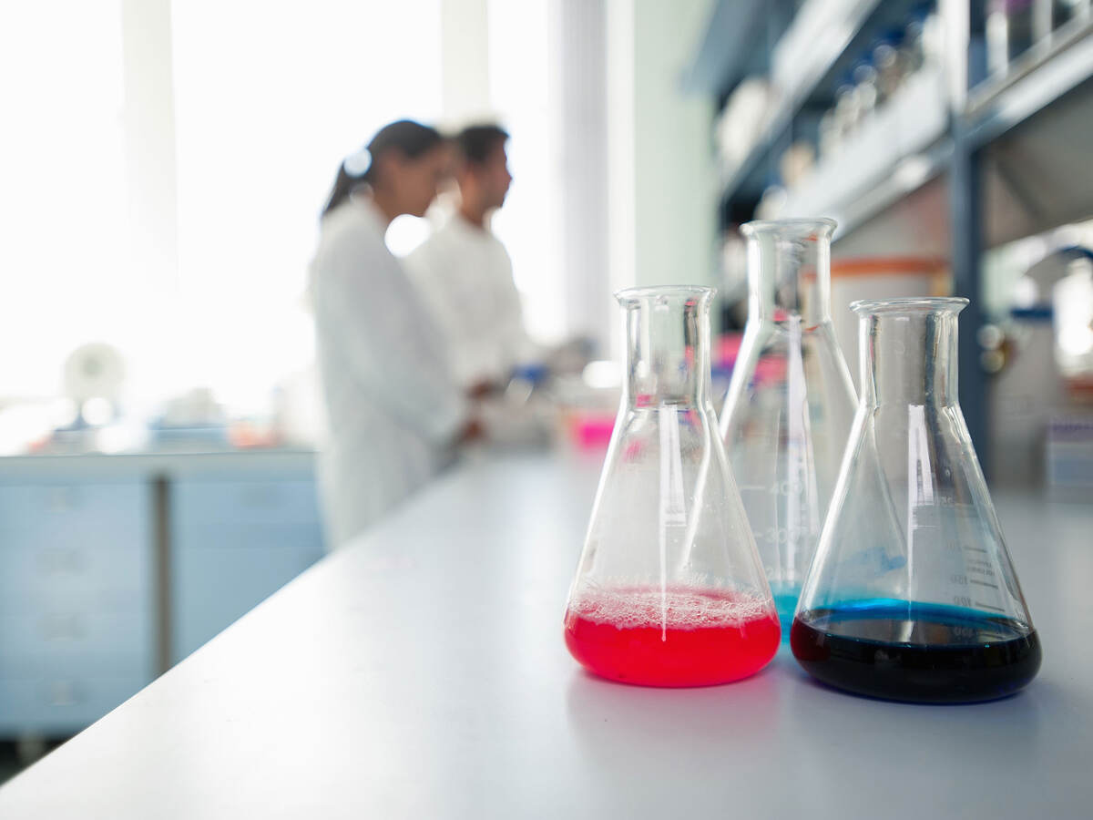 Flasks in foreground with scientists in background