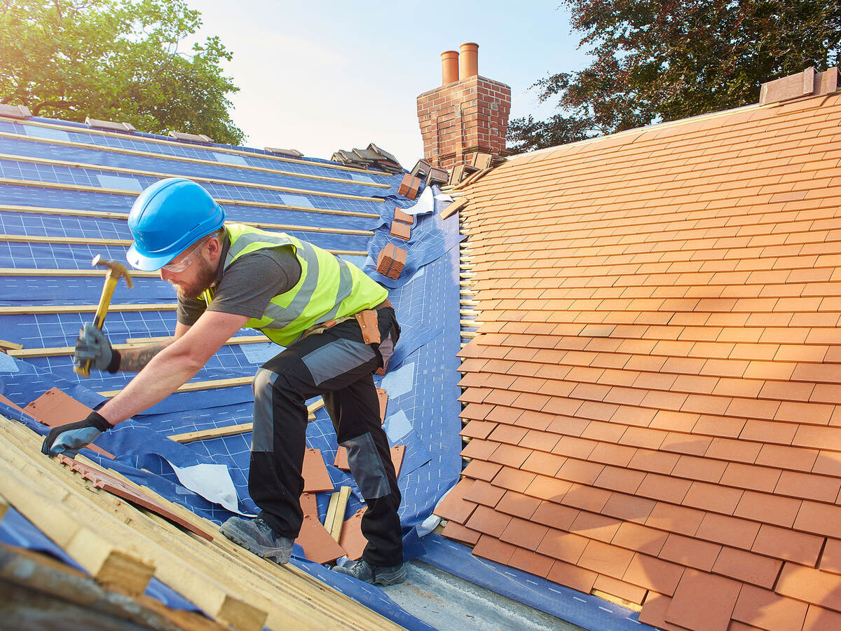 A person replacing roof tiles