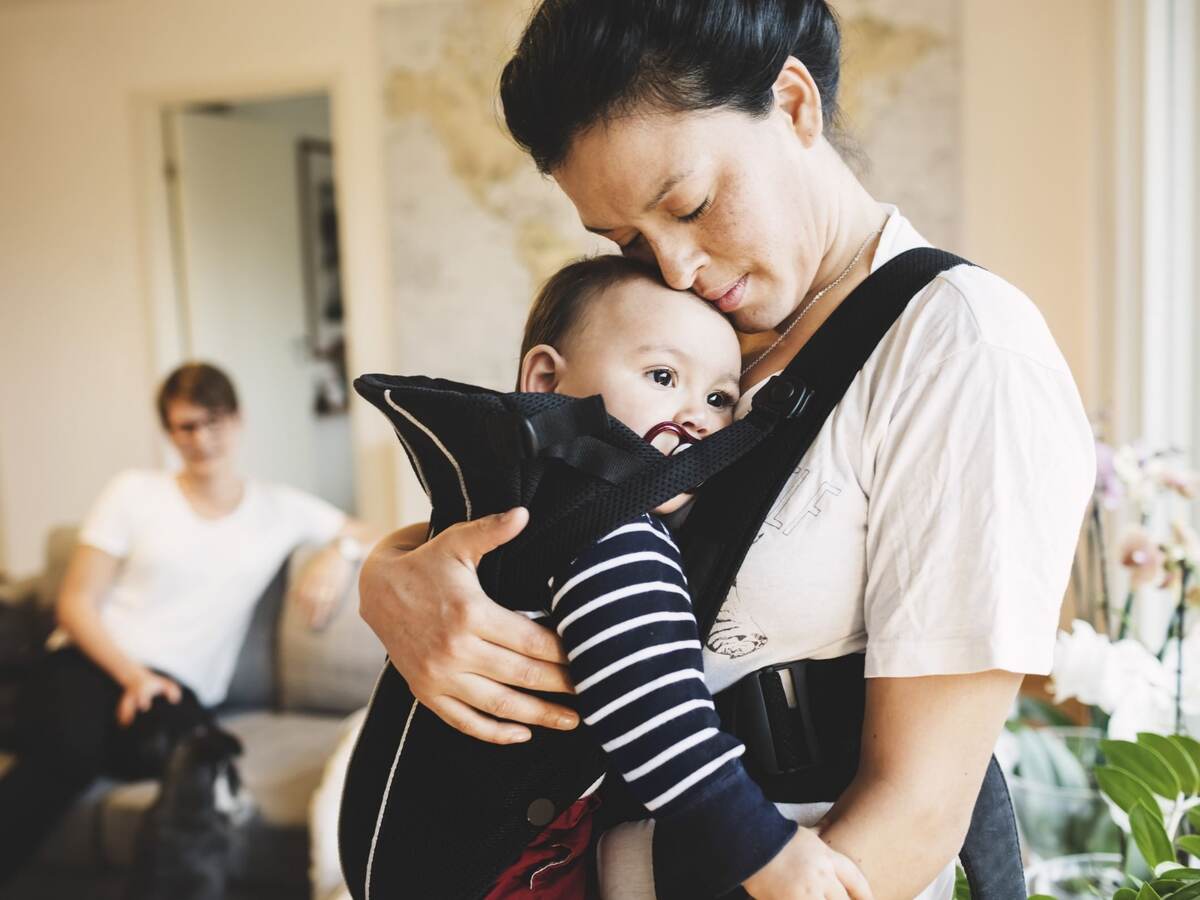 Mother holding baby in soft carrier