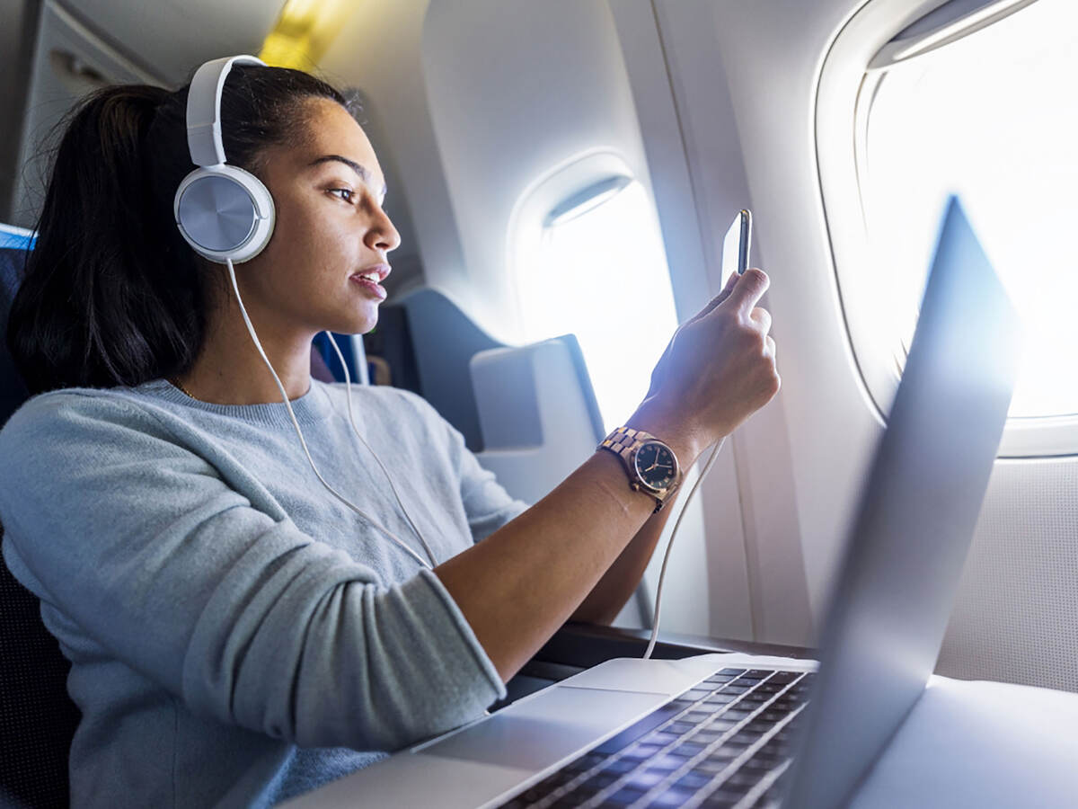 A person wearing headphones and working on a laptop.