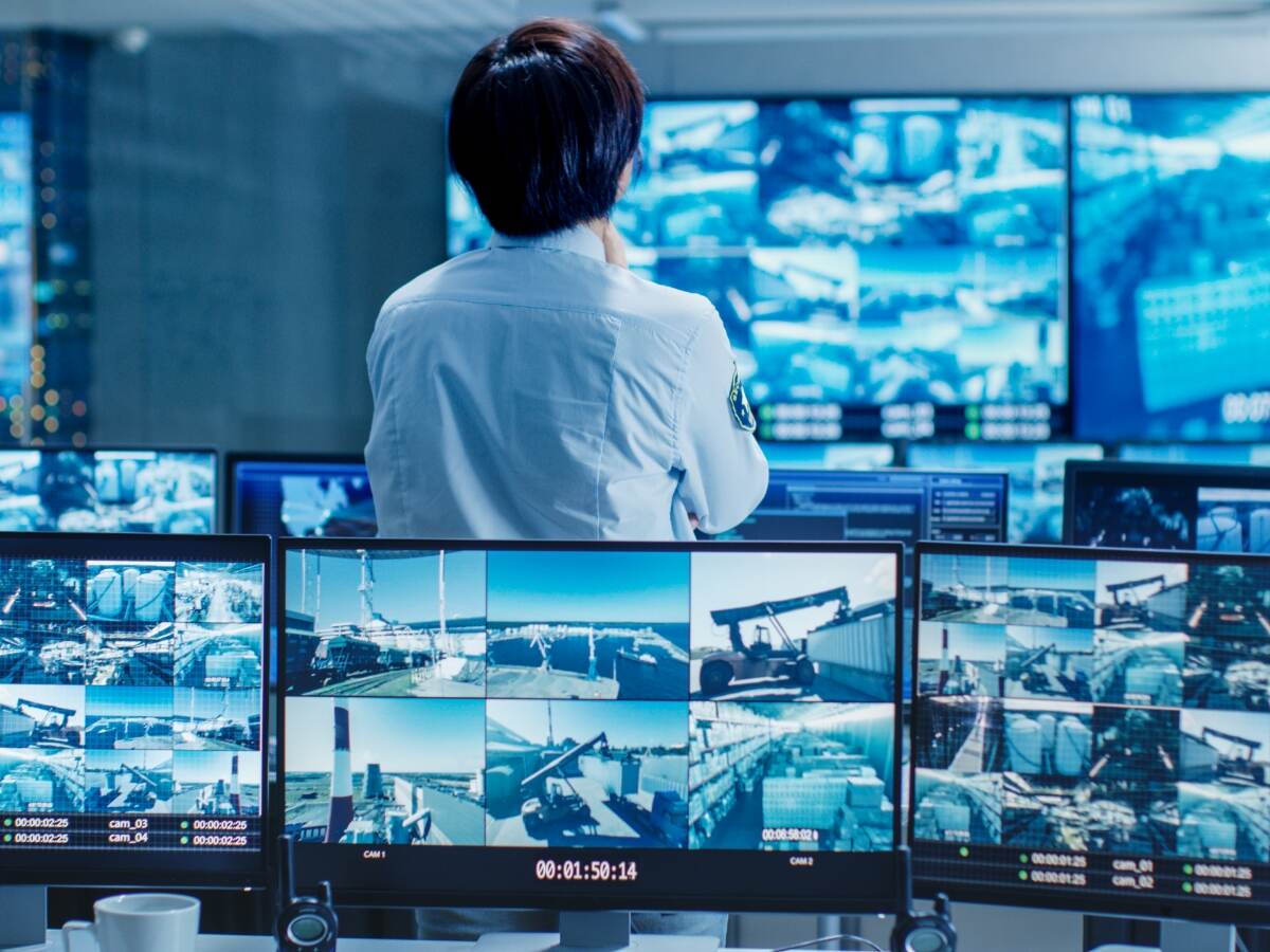 A control room security officer looking at several monitors