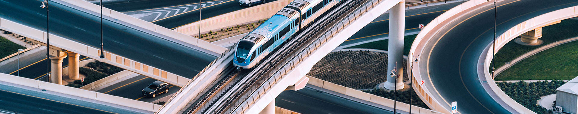 Train on a raised track above highway traffic