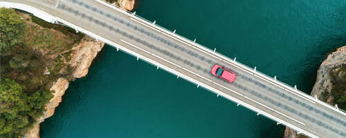 Overhead view of a car going across a bridge
