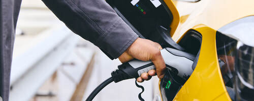 Person plugging their electric vehicle into a charger